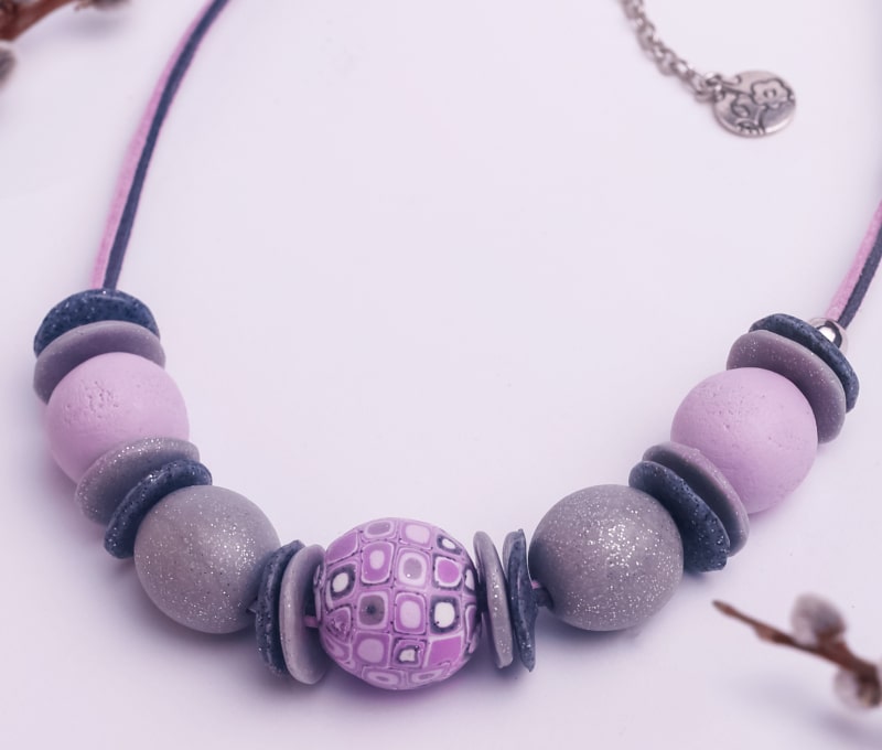 An attractive polymer clay necklace with five beads separated by colorful discs